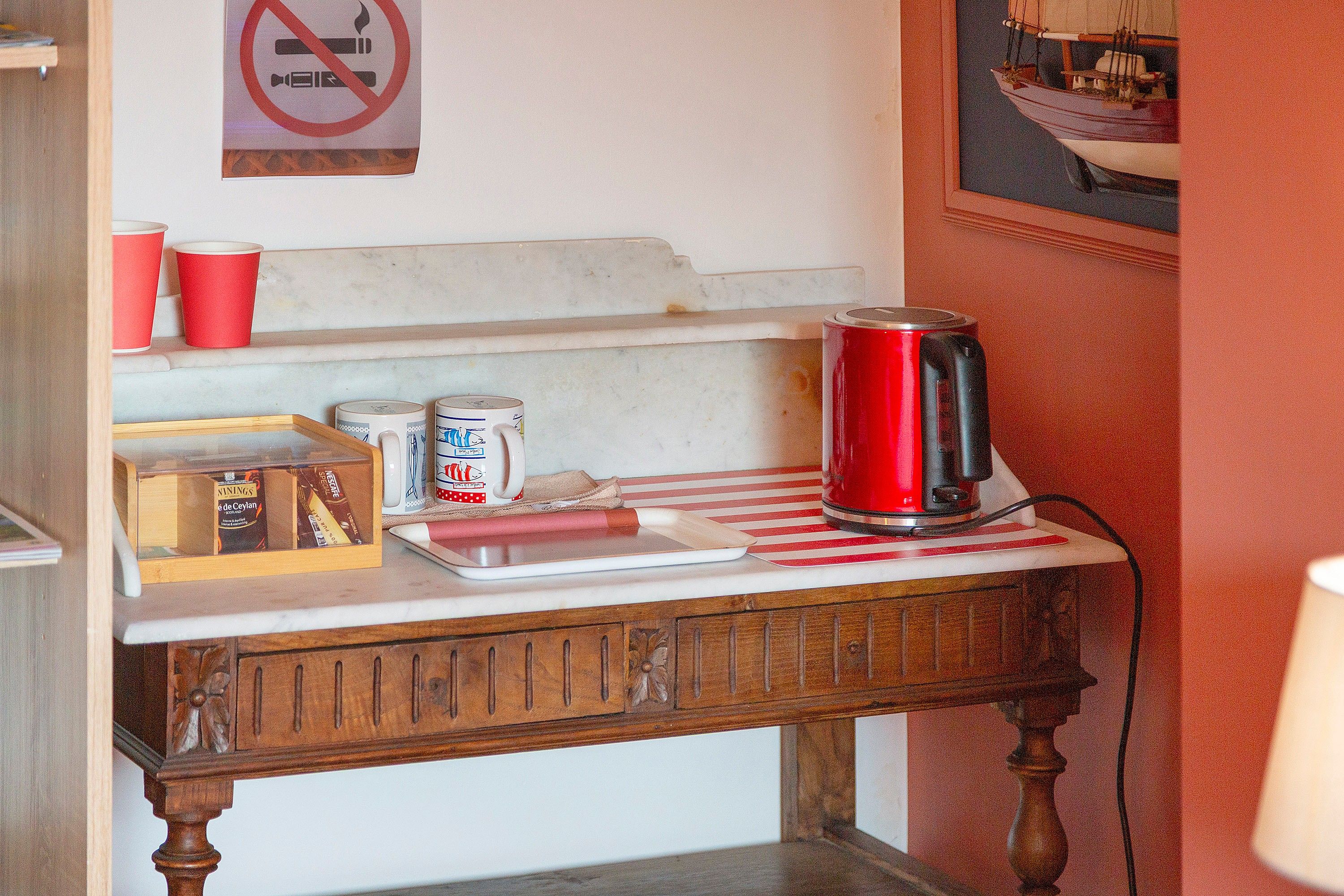 Een keukentafel met een koffiezetapparaat, een dienblad en een houten kastje.