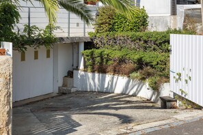 A narrow alleyway with a white fence, a small concrete structure, and dense foliage. - Les Sauges B&B Benodet Town (800 m from Beach) Breakfast Included (Bénodet)