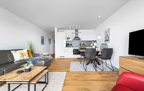 Ein modernes Wohnzimmer mit einer Couch, einem Couchtisch und einem Essbereich mit Stühlen und einem Tisch.