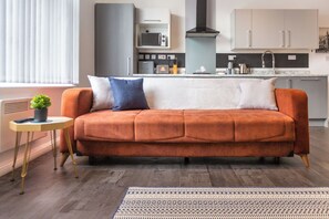 A modern living room with a sofa, a small side table, and a patterned rug. - South Pier Apartment 6 (Blackpool)