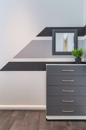 Een moderne dressoir met meerdere laden en een spiegel erboven.