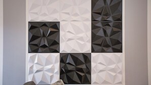 Eine Wand mit geometrischen Mustern in verschiedenen Grautönen.