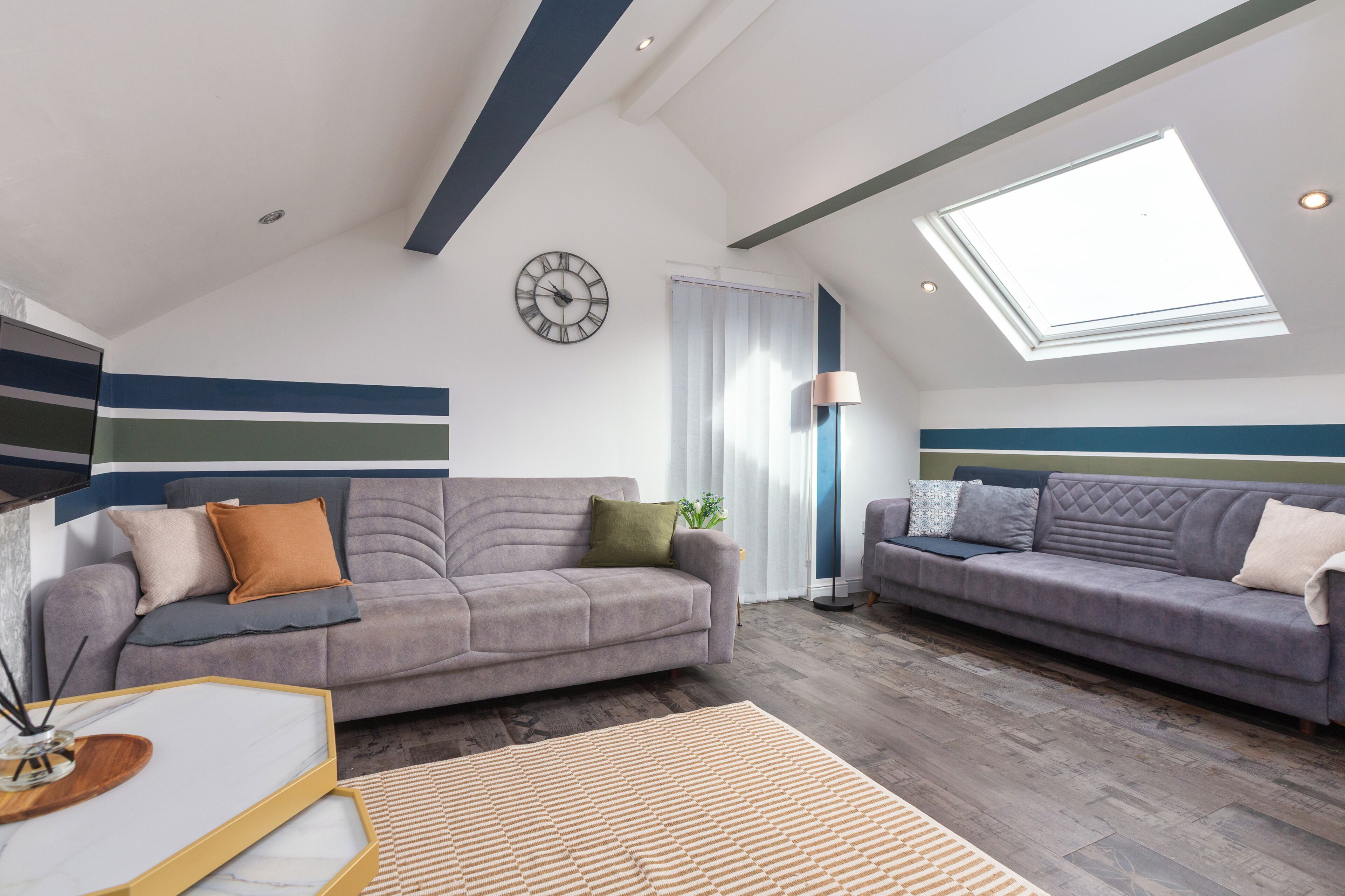 Een moderne woonkamer met twee banken, een salontafel en een groot raam.