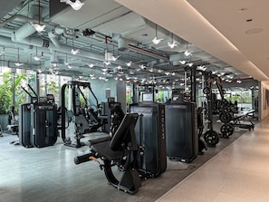 A modern gym with various exercise machines, large windows, and a clean, industrial design. - Canal View Studio Near Dubai Mall (Dubai)
