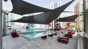 A rooftop pool area with a clear view of the city skyline, including high-rise buildings. - Canal View Studio Near Dubai Mall (Dubai)