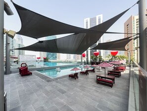 A rooftop pool area with a clear view of the city skyline, including high-rise buildings. - Canal View Studio Near Dubai Mall (Dubai)
