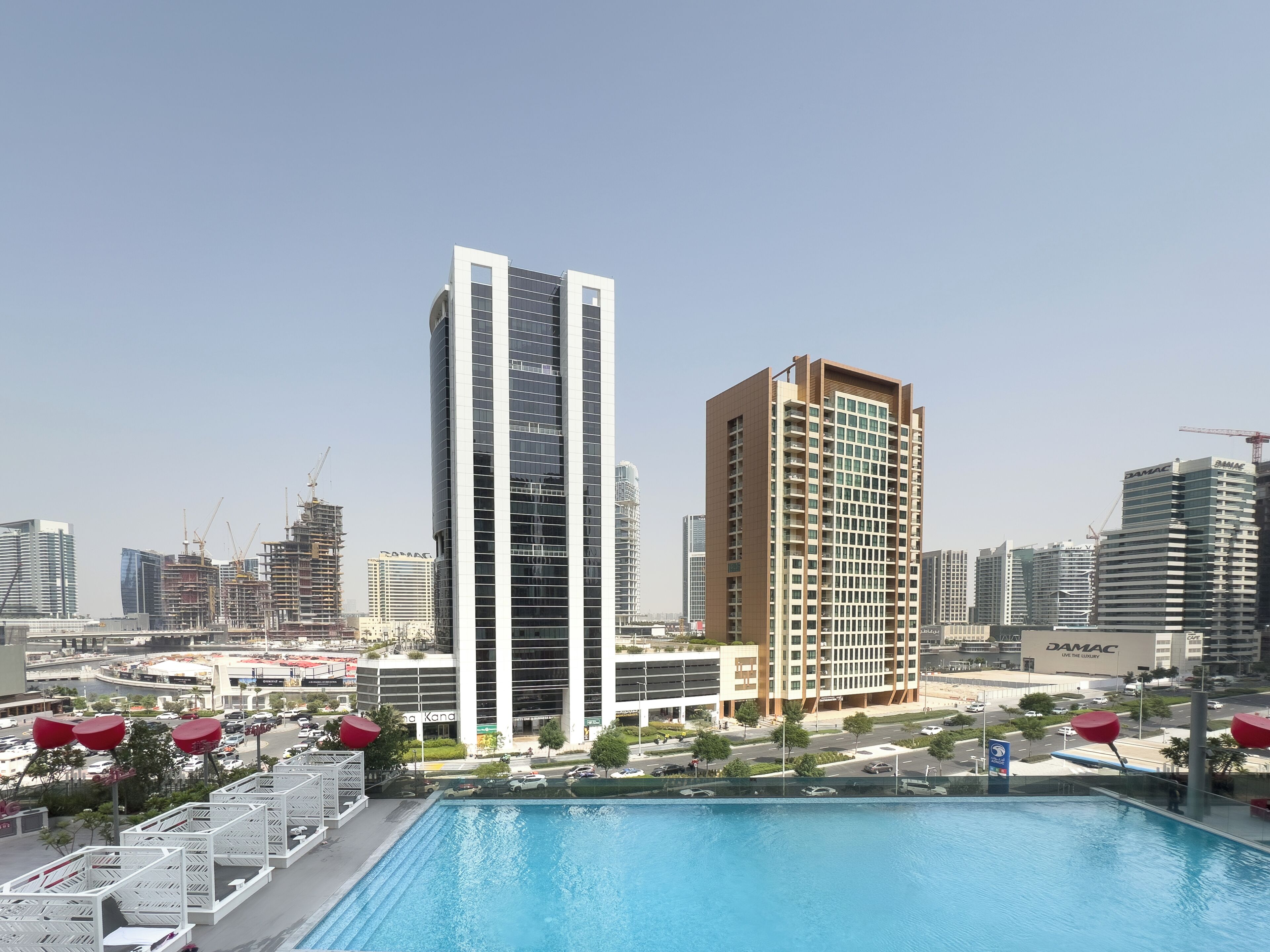 A modern building with a pool and outdoor seating area.