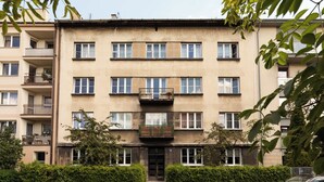 A multi-story residential building with balconies, a gated entrance, and a parking area. - Pułaskiego 7C | Perfect for Couples | AC (Kraków)