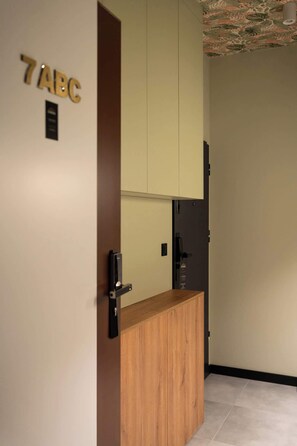 Ein Zimmer mit einem Holzkabinett, einer Tür mit der Aufschrift '7ABC' und einer Decke mit einem Blumenmuster.