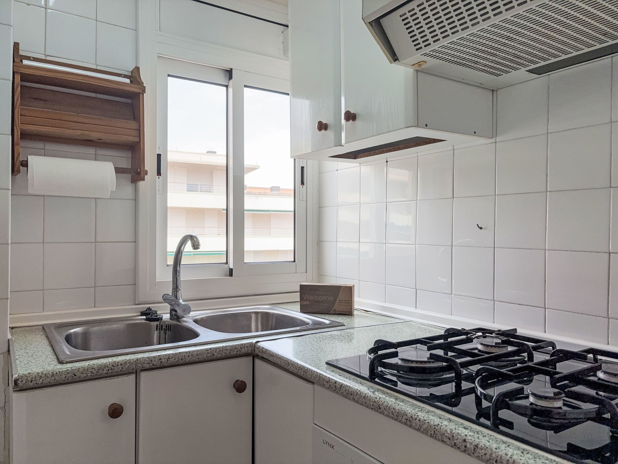 A kitchen with a double sink, stainless steel faucet, and a gas stove.
