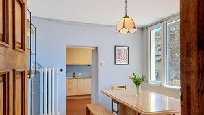 A kitchen with a dining table, bench, and a hanging light fixture. - Casa Yakamos by Interhome (Brissago)