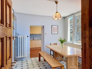 A kitchen with a dining table, bench, and a hanging light fixture. - Casa Yakamos by Interhome (Brissago)