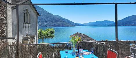 Een eettafel met uitzicht op een meer en bergen.