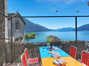 A table set for dining with a view of a lake and mountains. - Casa Yakamos by Interhome (Brissago)