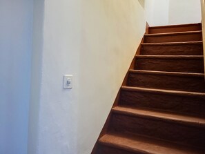 A staircase with a light-colored wall and a switch on the wall. - Casa Yakamos by Interhome (Brissago)