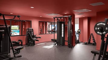 A gym with various exercise equipment, including a squat rack, weight bench, and dumbbells.