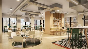 A modern library with multiple seating areas, bookshelves, and large windows.