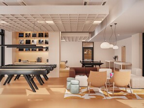Ein modernes Interieur mit Billardtisch, einer Sitzecke und einer Wand mit gerahmten Bildern.