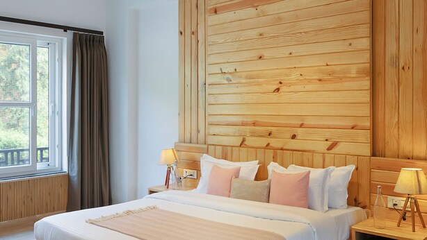 Un'ampia camera da letto con un grande letto, testiera in legno e ventilatore a soffitto.