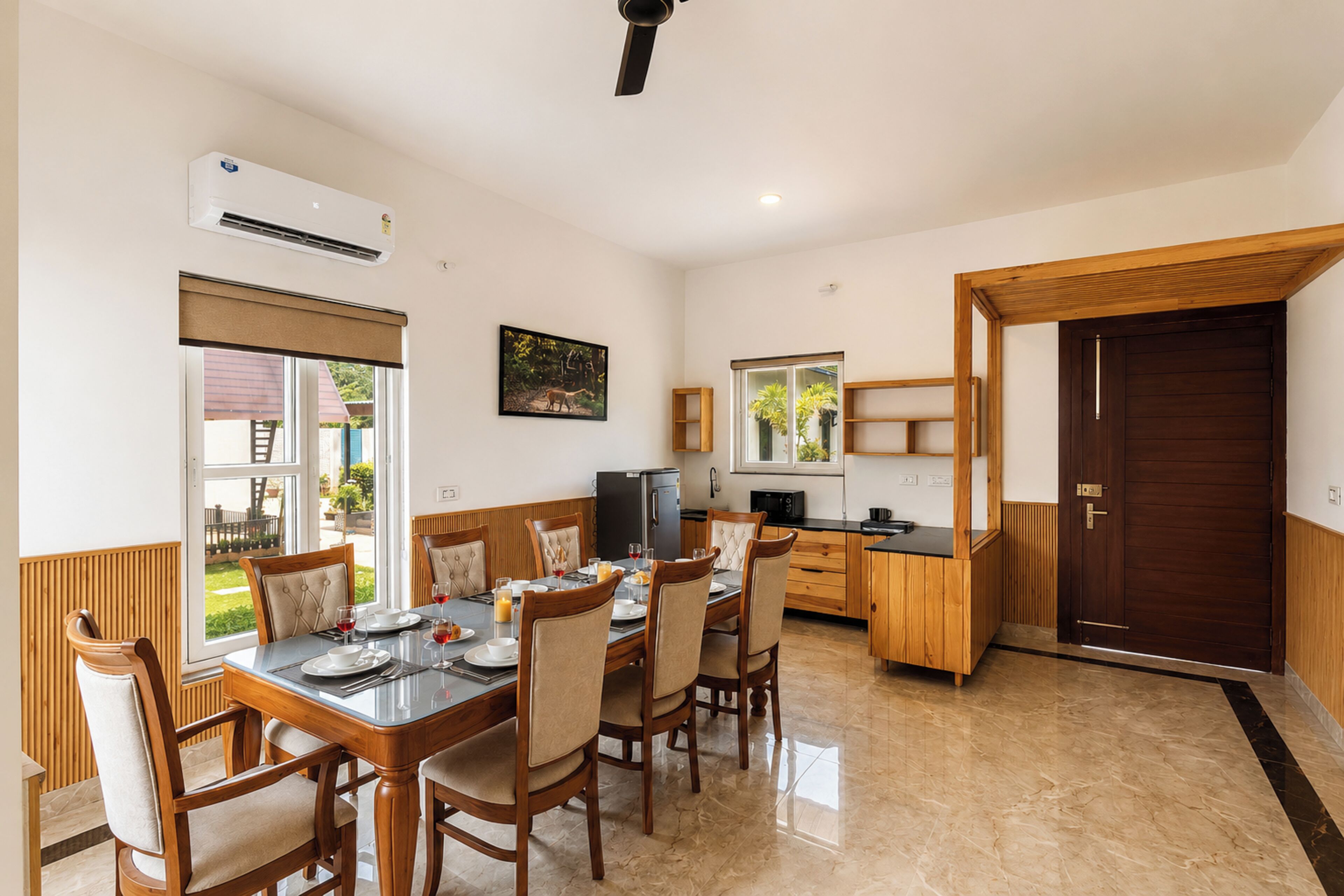 Una cocina moderna con zona de comedor, armarios de madera y un amplio ventanal.