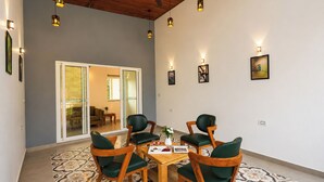 Un'area pranzo con tavolo e sedie, una ventola a soffitto e luci a parete.