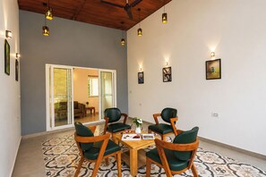 Un comedor con una mesa, sillas, un ventilador de techo y luces en la pared.