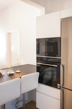 Departamento de lujo, vista parcial al mar | Cocina privada | Refrigerador con congelador, horno y parrilla de estufa 