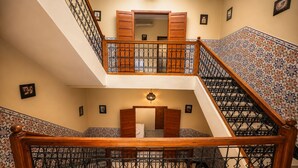 A multi-level interior with a wooden staircase, ornate metal railings, and patterned wall tiles. - Riad Kamin And Pool (Marrakech)
