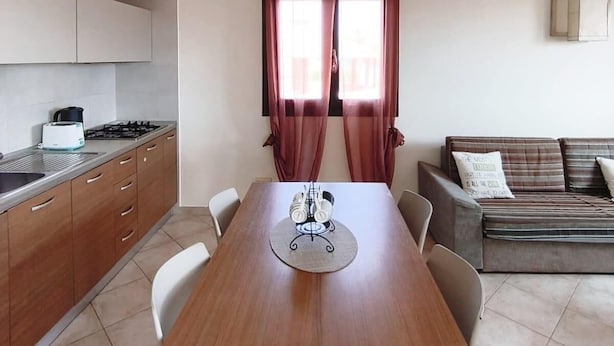 A compact living space with a dining table, kitchen area, and a ceiling fan. - HostySpot - Tropical Resort, 1-Bedroom Apartment (Santa Maria)