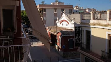 A building with a balcony, a staircase, and a small shop with a sign.
