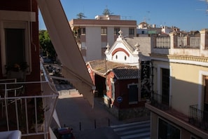 A building with a balcony, a staircase, and a small shop with a sign.