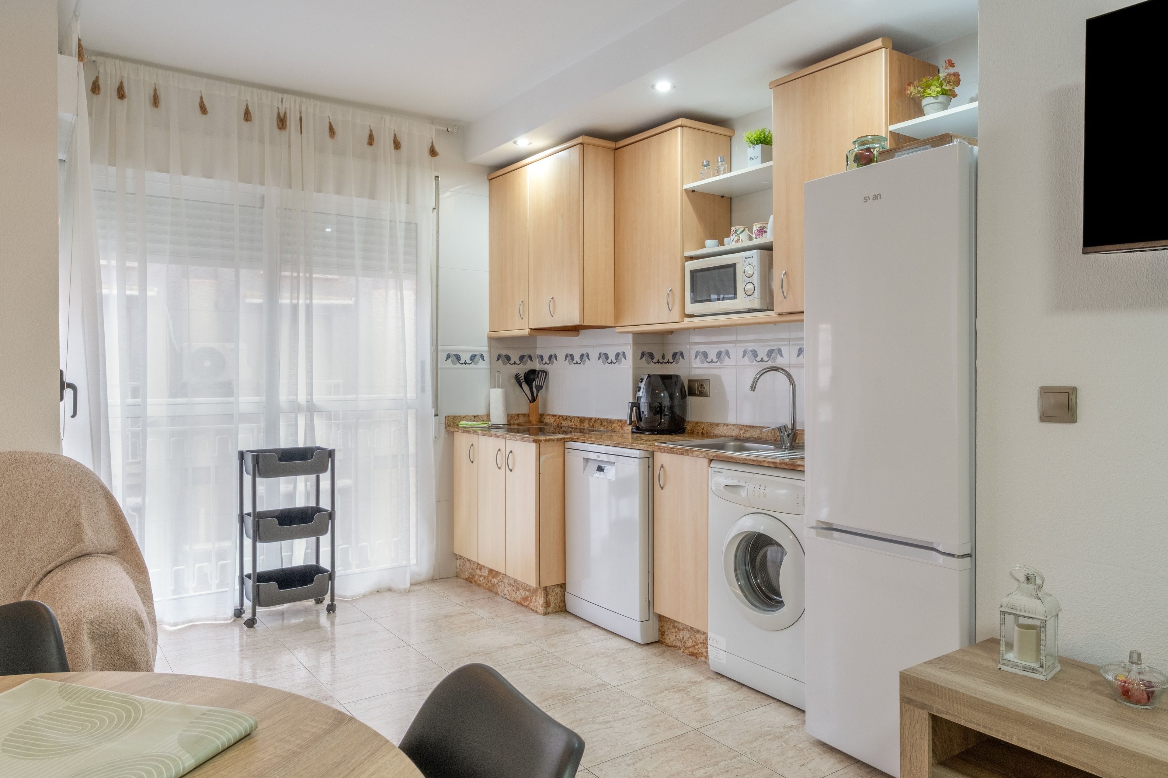 A compact kitchen with a microwave, toaster, and washing machine.