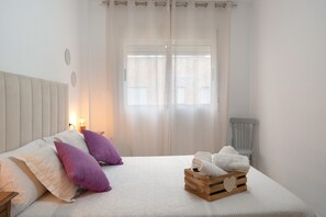 A bedroom with a bed, pillows, a bedside table, a nightstand, a window with curtains, and a chair. - Aguilas Center & Costa, with Balcony, Wi-Fi and Air Conditioning (Aguilas)