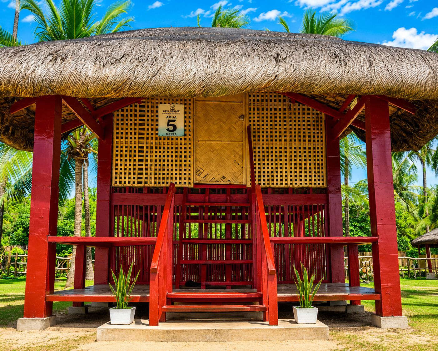 A thatched-roof structure with a sign indicating 'CAJA GRANDE AQUA 5 MELSA'.