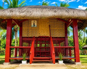 A thatched-roof structure with a sign indicating 'CAJA GRANDE AQUA 5 MELSA'. - Calilayan Cove Beach Resort (Unisan)