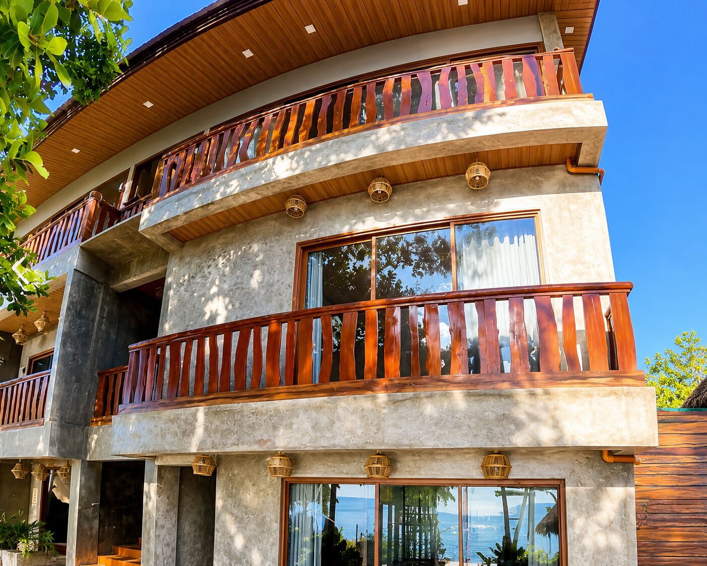 Un edificio de varios pisos con balcones, ventanas grandes y vista al mar.