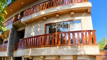Un edificio de varios pisos con balcones, ventanas grandes y vista al mar.