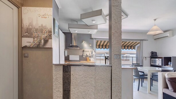 A modern kitchen with a brick accent wall, a dining area with a view, and a kitchenette with a microwave.