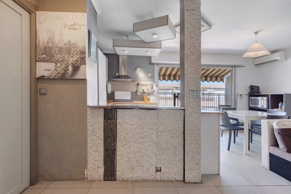 A modern kitchen with a brick accent wall, a dining area with a view, and a kitchenette with a microwave.