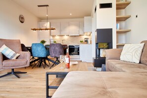 A modern living room with a sofa, chairs, a coffee table, and a TV. - Baltic Sea Horizon – Penthouse. Sauna. Roof terrace. (Kellenhusen)