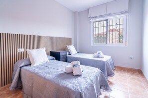 A hotel room with two beds, a wooden headboard, a window with bars, and a tiled floor. - Cubo's Buddha Harmony House / Private pool / Air conditioning / BBQ / Free Wi-Fi (Pizarra)