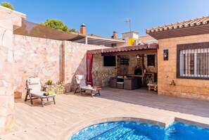 A poolside area with a stone wall, two lounge chairs, a barbecue grill, and a small pool. - Cubo's Buddha Harmony House / Private pool / Air conditioning / BBQ / Free Wi-Fi (Pizarra)