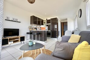 A modern living room with a TV, sofa, and a small coffee table. - Swimming pool with a 100-meter cable winch, located 100 meters from the beach* (Guidel)