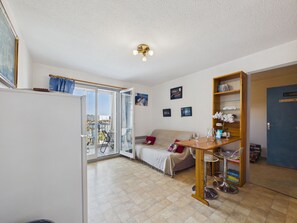 A compact living space with a sofa, a dining table, and a bookshelf. - Port Olona View - Apartment for 4 (Les Sables-d´Olonne)