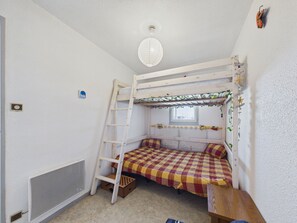 Quarto com beliche, janela e radiador.