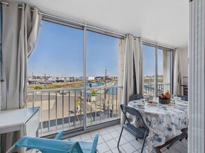 A balcony with a table and chairs, overlooking a marina with boats. - Port Olona View - Apartment for 4 (Les Sables-d´Olonne)