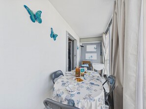 Ein Essbereich mit Tisch für zwei Personen, Tischdecke mit Meeresmotiv.
