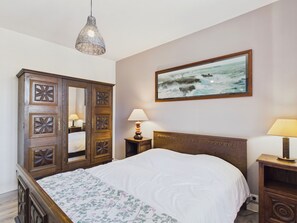 A bedroom with a wooden bed, a nightstand, a mirror, a hanging light fixture, and a framed picture of the sea on the wall. - House for 8 p, 400m from the beach, Kerlouan (Kerlouan)