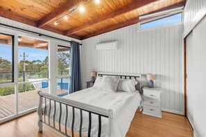 A bedroom with a bed, bedside tables, a window, and a view of the outdoors. - The Timeless Coastal - moments walk to town (Aireys Inlet)