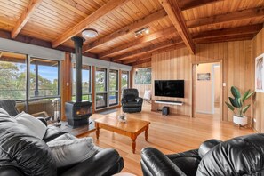 A spacious living room with a large fireplace, leather furniture, and a television. - The Timeless Coastal - moments walk to town (Aireys Inlet)